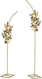 two tall gold metal flower stands with flowers on each side and one standing in the middle