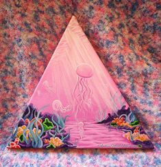 a triangle shaped painting with an octopus and jellyfish in the ocean on it's side