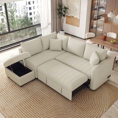 a living room with a large sectional couch and coffee table in front of the window