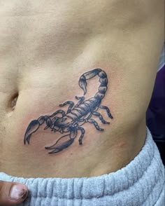 a man's stomach with a scorpion tattoo on it