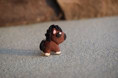 a small toy horse sitting on the ground