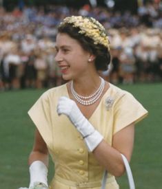 a woman in a yellow dress holding a white bag