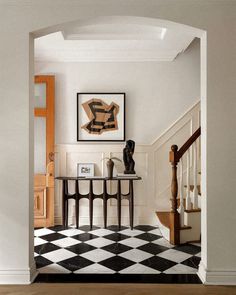 an entry way with a checkered floor and black and white tile on the floor