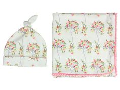 a baby's hat and blanket set with flowers on white fabric, pink trim