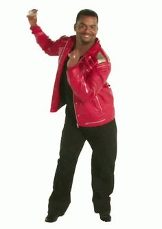 a man in a red jacket and black pants with his hand up to the side