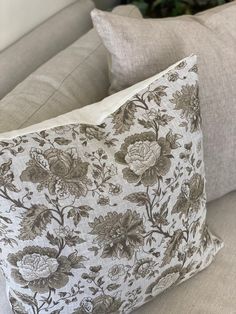 a white and brown pillow sitting on top of a couch