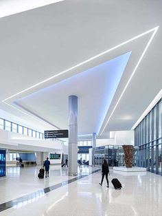 people are walking through an airport with their luggage