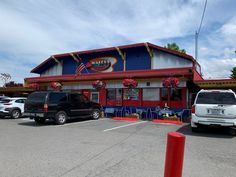 the outside of a restaurant with cars parked in front