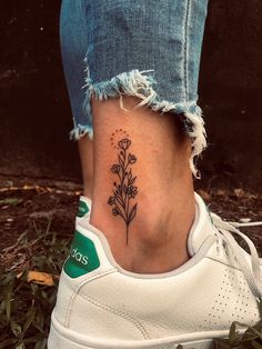 a woman's foot with a small flower tattoo on the left side of her ankle