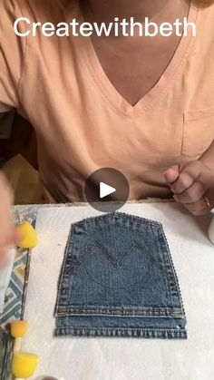 a woman sitting at a table with a piece of denim in front of her