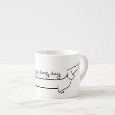 a white coffee mug with a drawing of a dachshund on it's side