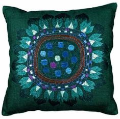 a green pillow with blue and purple designs on it