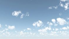 the sky is filled with white clouds and blue water in front of an empty beach