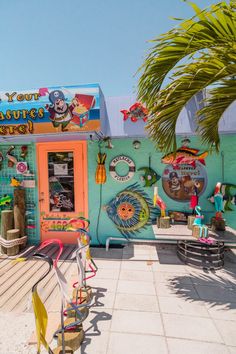 a brightly colored building with lots of decorations on the front and side of it, along with palm trees