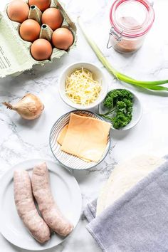 ingredients for sausage and eggs laid out on a marble counter top, ready to be cooked