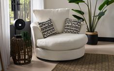 a living room with a white chair and some plants