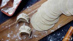 dumplings on a wooden cutting board with flour