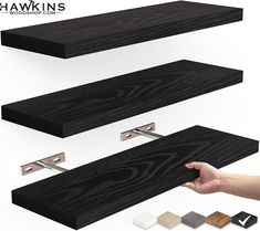 a hand is holding the edge of a wooden shelf with different colors and finishes on it