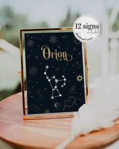 the zodiac sign is on display in front of a wooden table with white feathers and a black background