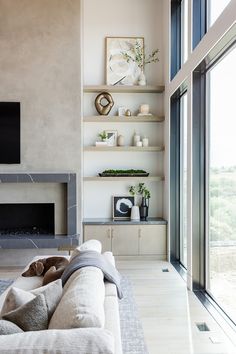 a living room filled with furniture and a flat screen tv mounted on a wall next to a fire place