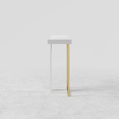 a white table with gold legs on a plain surface