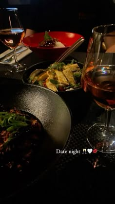 a table topped with plates of food and glasses of wine