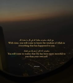 an airplane window looking out at the night sky and cityscape with a quote written in arabic