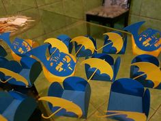 blue and yellow chairs with umbrellas on them in front of a mirror at a restaurant