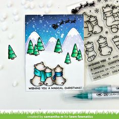 a christmas card with stamps, markers and marker pens on the table next to it