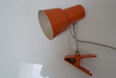 an orange desk lamp is on the wall