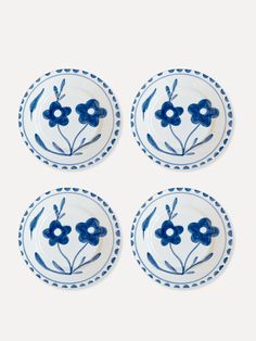 four blue and white plates with flowers on them