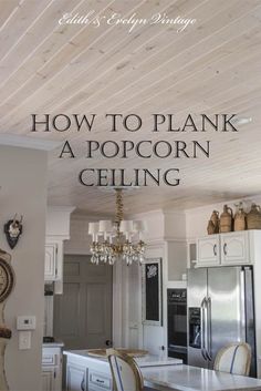 a white kitchen with a chandelier hanging from the ceiling