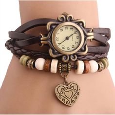 This Boho-Chic Vintage-Inspired Handmade Watch is the ultimate bohemian accessory, it adds some instant vintage-inspired style to any look. Made from vegan leather, this woven cuff-style bracelet is accented by beautiful beads and a sweet heart charm. Additional Information 1.Material: genuine leather 2.Handcrafted 3.Wrap-around-the-wrist design 4.Measures approximately 8.25" L x 0.5" W 5.Fits up to 8" wrist 6.Snap-back closure Bracelet Design Ideas, Boho Watch, Wrist Watch Design, Wristwatch Vintage, Novelty Store, Heart Vintage, Handmade Watch, Bracelet Watches Women, Bohemian Accessories