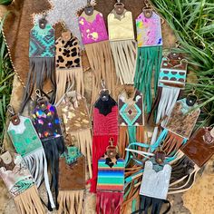 many different pieces of leather with fringes and beads on them sitting in the grass