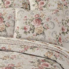 a bed with floral bedspread and pillows