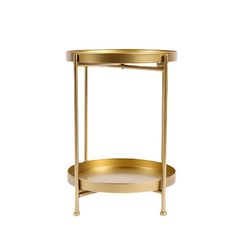 a round gold metal table with two shelves on each side and one shelf holding a tray