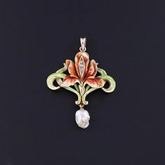 Antique Iris Pendant: This Art Nouveau era 14k gold pendant features an iris flower adorned with lustrous green and red enamel and three diamond accents.  A baroque pearl dangles beneath the piece.  The pendant was originally an antique brooch (circa 1880-1900) that our jeweler transformed by removing the pin findings and adding a bail. The piece measures 1.65 inches from the top of the bail to bottom by 1.15 inches wide and weighs 5.15 grams. It is in good condition with some loss to the enamel visible upon close inspection.  Upon purchase, your pendant will arrive elegantly packaged, ready for gifting or as a special treat for yourself.  We carefully wrap each piece to ensure a delightful unboxing experience. We also offer free and flexible layaway plans, so take advantage of this option Art Nouveau Tiara, Iris Pendant, Iris Flower, Antique Brooches, Iris Flowers, Green And Red, Antique Shops, Baroque Pearls, Gold Pendant