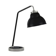 a black desk lamp with a metal base on an isolated white background, the light is dimming