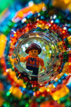 a lego man is in the center of a colorful glass ball with lights around it