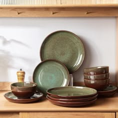 a wooden shelf with plates and bowls on it