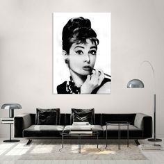 a black and white photo of a woman with her hand on her chin, in a living room