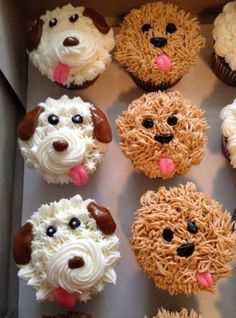 cupcakes with frosting and dog faces on them are arranged in a box