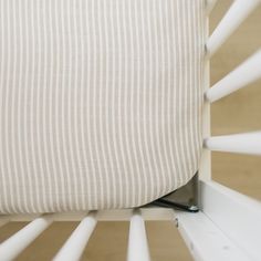 a close up view of the back end of a baby crib with white stripes