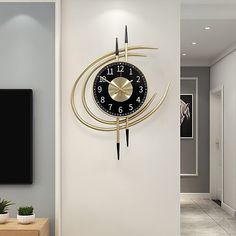 a clock that is on the side of a wall next to a tv and table