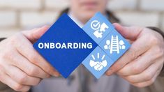 a man holding up a blue card with the word onboarding on it