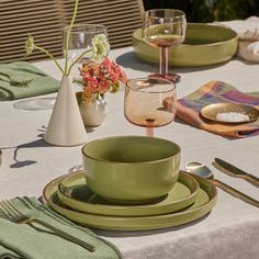 the table is set with green dishes and silverware