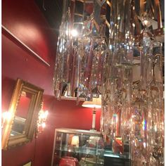 a chandelier hanging from the ceiling in a room with red walls and mirrors