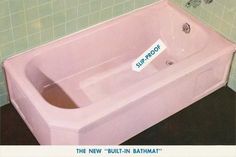 a pink bath tub sitting on top of a black floor next to a green tiled wall