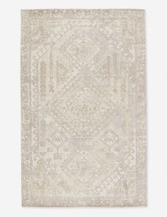 a beige and white rug with an intricate design on the bottom, in front of a light gray background