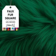 a tag that says faux fur square on top of a green furry animal's fur